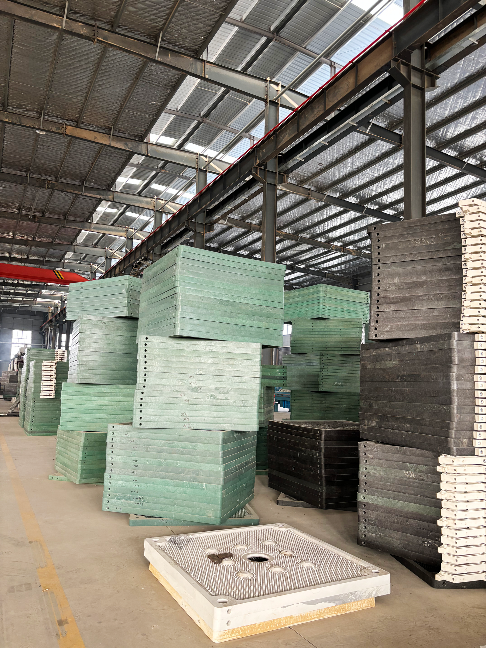 PP filter plate stacks in the factory warehouse with a single plate in the foreground
