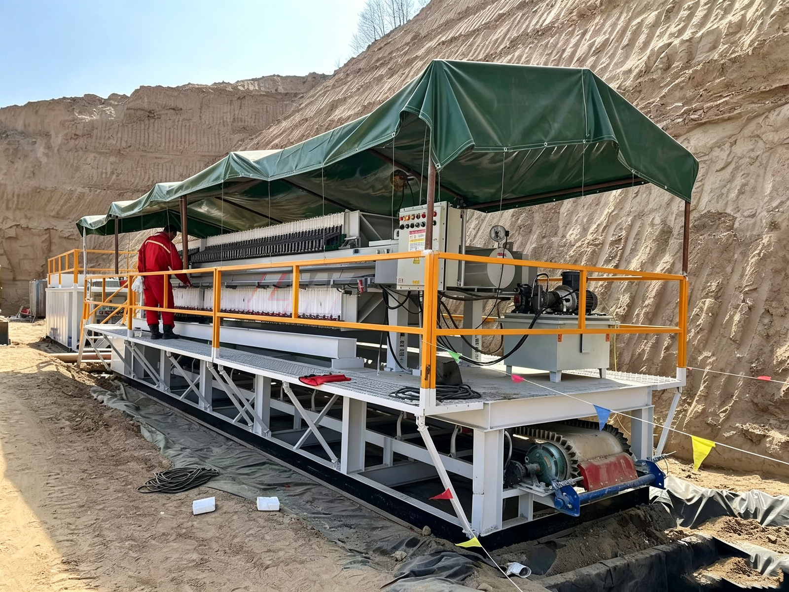 Loway skid-mounted filter press installed at a mining site with green weather canopy and yellow safety railings