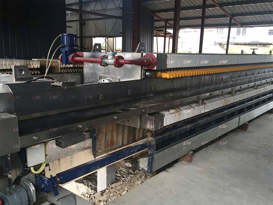 Filter press discharging cake under a shelter at a project site
